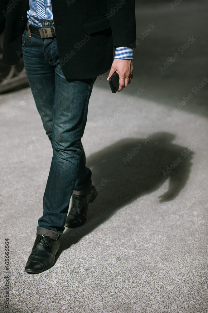 Modern communications. Businessman on street, unrecognizable male walking with mobile phone