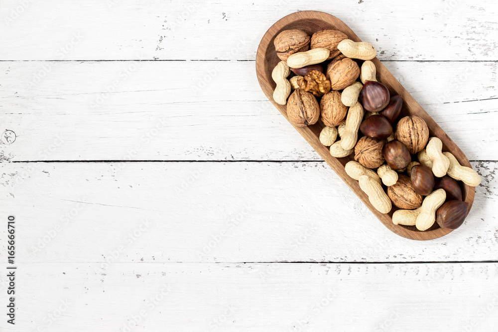 Mixed nuts in a bowl on a white wooden background. Copy space Mixed nuts in a bowl on a white wooden background. Copy space