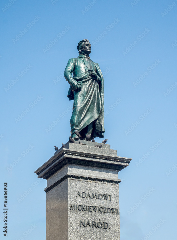 Obraz premium Bronze statue of Adam Mickiewicz, Polish national romantic poet and dramatist on Main Market Square in Krakow, Poland. Monument unveiled in 1898, now after cleaning in 2017.