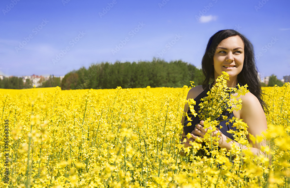 Beautiful woman among yellow flowers in a field Beautiful woman among yellow flowers in a field