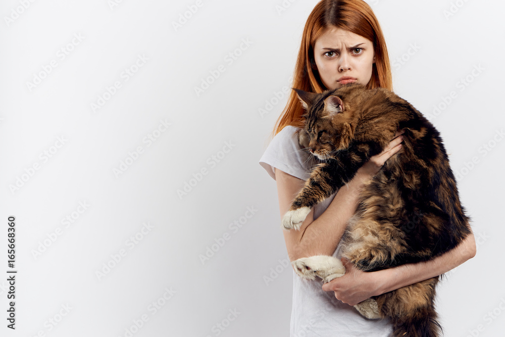 Young beautiful woman on white isolated background holds a cat