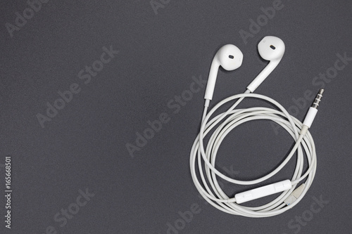 Top view of White Earphones on Black background. Copy space