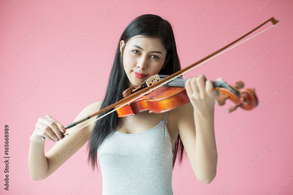 beautiful girl playing the violin on pink background beautiful girl playing the violin on pink background
