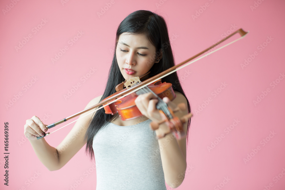 beautiful girl playing the violin on pink background beautiful girl playing the violin on pink background