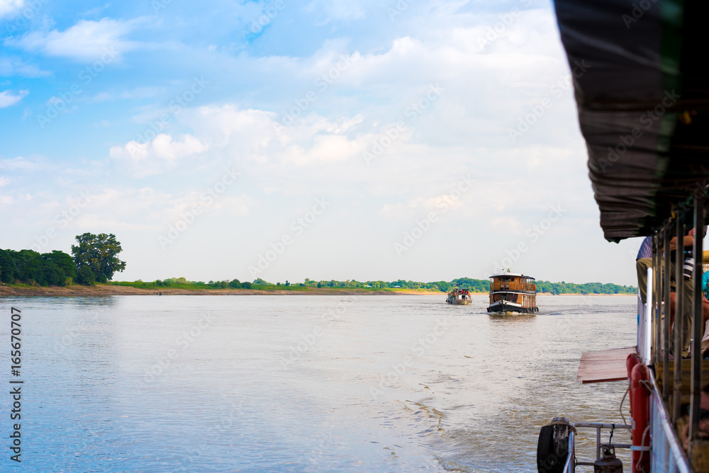 Obraz premium Tourist boats on the Irrawaddy river, Mandalay, Myanmar, Burma. Copy space for text.