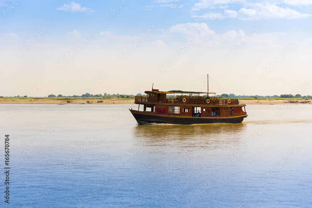 Fototapeta premium Pleasure boat on the river Irravarddy, Mandalay, Myanmar, Burma. Copy space for text.