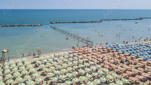 Foto Dalla riviera romagnola vista aerea di ombrelloni colorati disposti in fila sulla spiaggia di Riccione