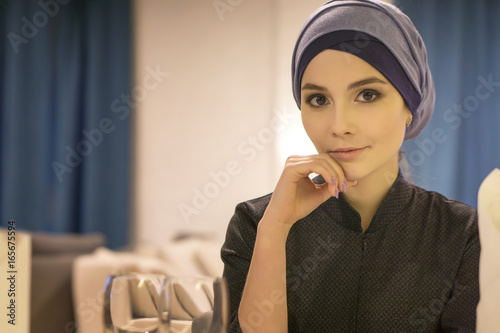 Portrait of a beautiful muslim woman at a table in a cafe