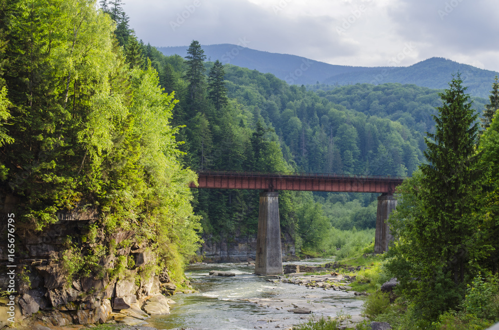 mountain river with a rapid current of rocks and a bridge mountain river with a rapid current of rocks and a bridge