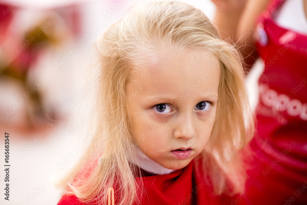Hairdresser making a hair style to cute little girl Hairdresser making a hair style to cute little girl