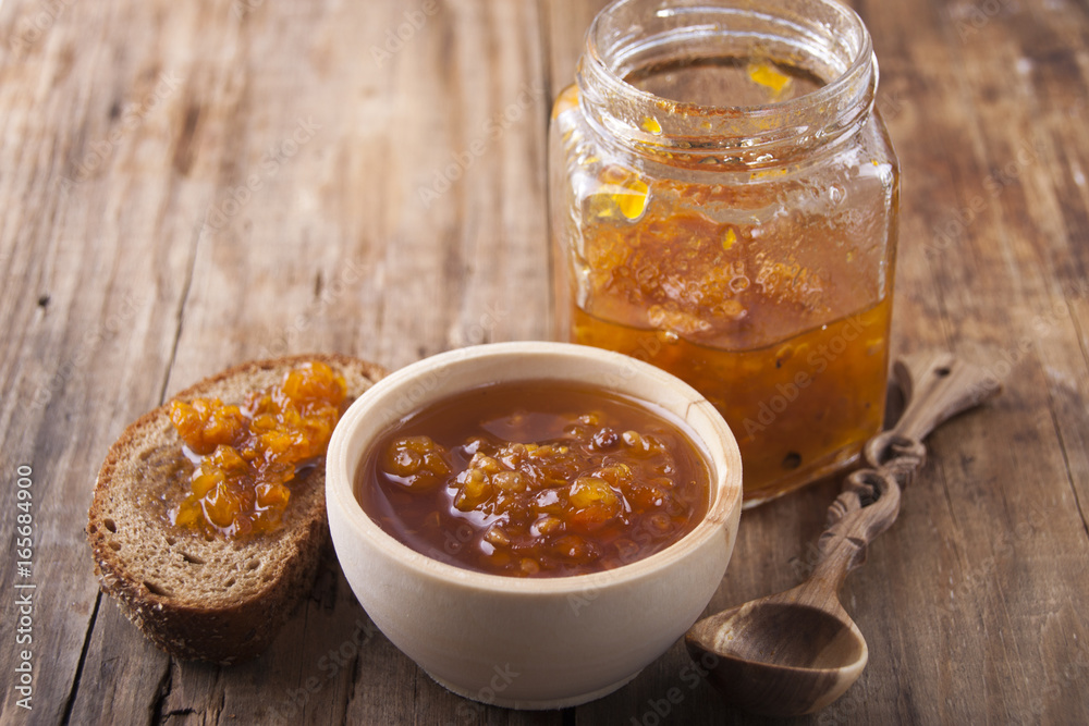 Cloudberry jam in a glass jar and bread with jam Cloudberry jam in a glass jar and bread with jam