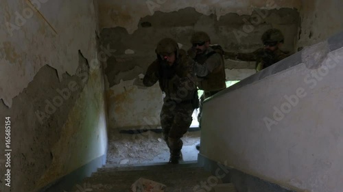 Group of military soldiers armed training at the tactical exercise in an abandoned building