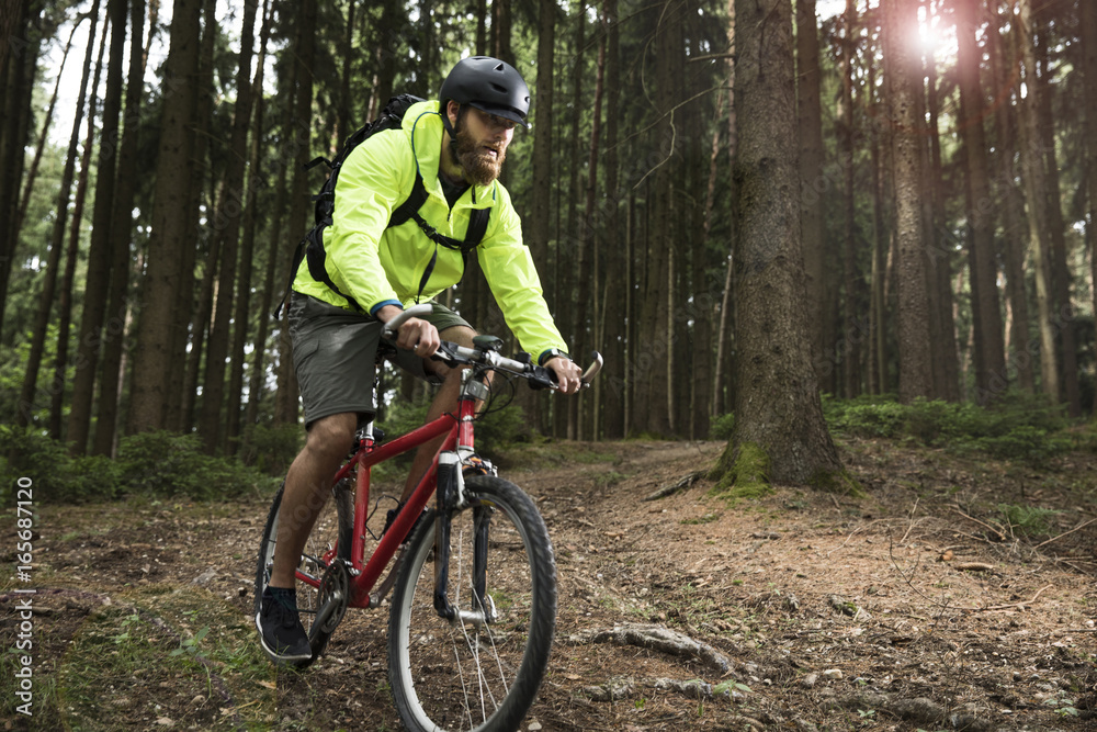 Man mountain biking in forest Man mountain biking in forest