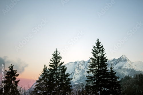 Sunrise through the hills of the forested mountains in the winter
