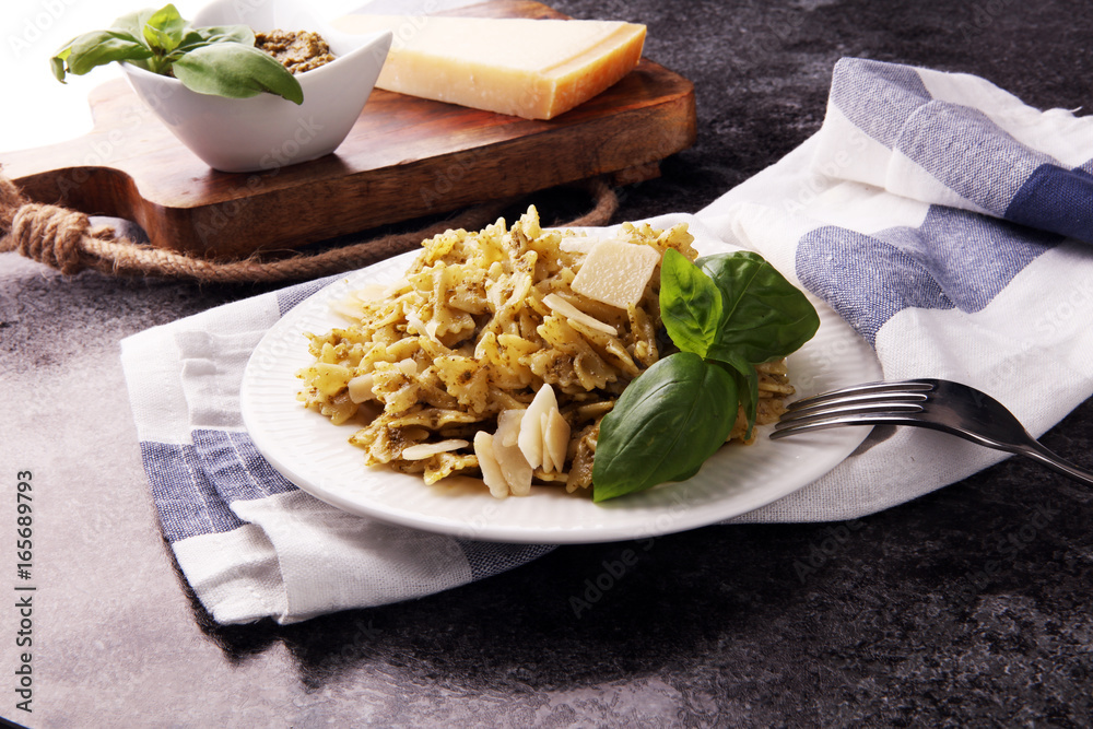 Farfalle pasta bows with pesto on a plate on a rustic background Farfalle pasta bows with pesto on a plate on a rustic background