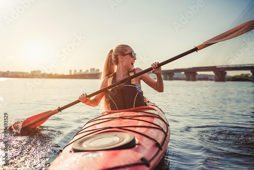 Woman kayaking on sunset
