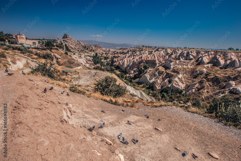 View of ancient Nevsehir cave town and a castle of Uchisar dug from a mountains in Cappadocia, Central Anatolia,Turkey. Cappadocia,Kapadokya,Turkish heritage travel. Uchisar pigeon valley.