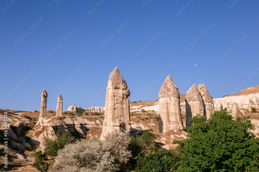 Fairy tale chimneys in Cappadocia on the background of blue sky in Turkey.The great tourist attraction of Cappadocia one of the best places to fly with hot air balloons. Goreme, Cappadocia, Turkey