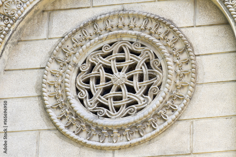 Stone rosette - window made of decorated stone, ornaments and relief on the Orthodox church from Serbia.