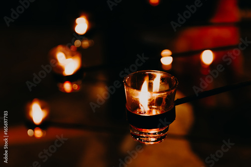 Candles light background and wallpaper. Christmas candles burning at night. candle flames glowing in the dark.