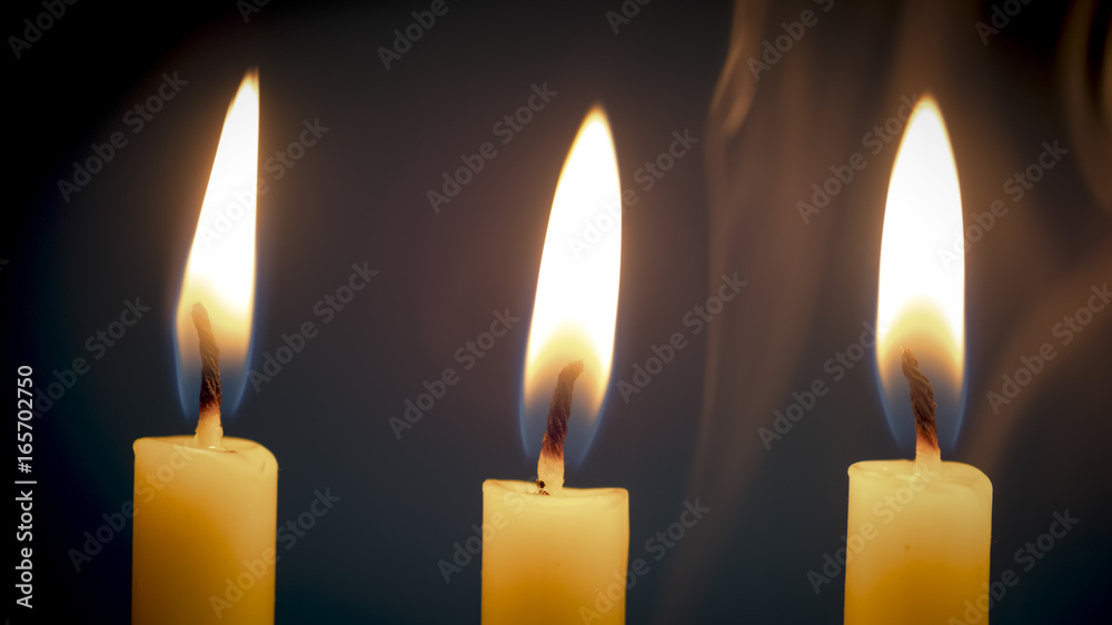 Group of still life golden candle light with smoke over dark background. Abstract background for pray or meditation caption and hope concept. Group of still life golden candle light with smoke over dark background. Abstract background for pray or meditation caption and hope concept.