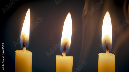 Group of still life  golden candle light with smoke over dark background.  Abstract background for pray or meditation caption and hope concept.