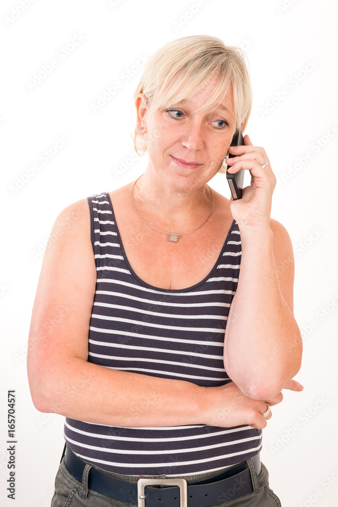 portrait of a attractive blond haired mid aged european woman wearing blue striped top acting with cellular phone - studio shot on white background. portrait of a attractive blond haired mid aged european woman wearing blue striped top acting with cellular phone - studio shot on white background.