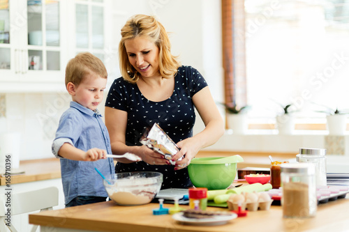 Smart cute child helping mother in kitchen