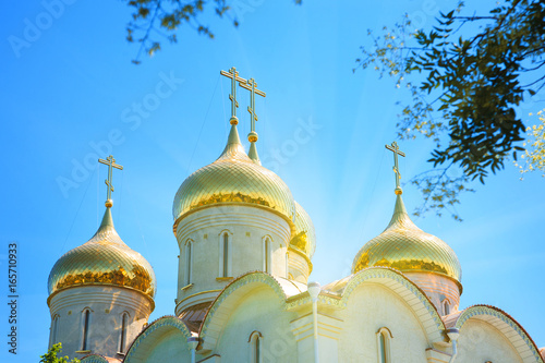 Golden domes of the Orthodox church against the blue sky. photo