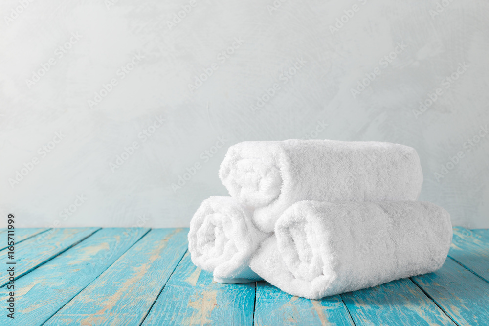 Stack of bath towels on wooden table with copy space Stack of bath towels on wooden table with copy space