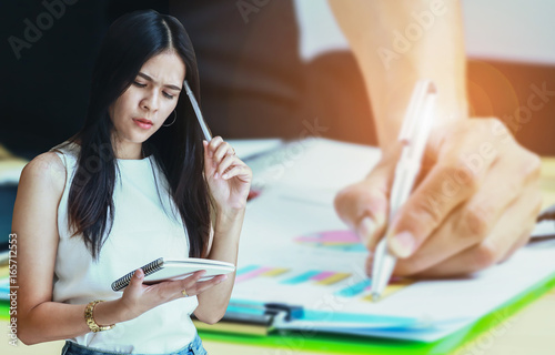 Serious business woman using notebooks on background Businessman analyzing investment charts selective focus, photo