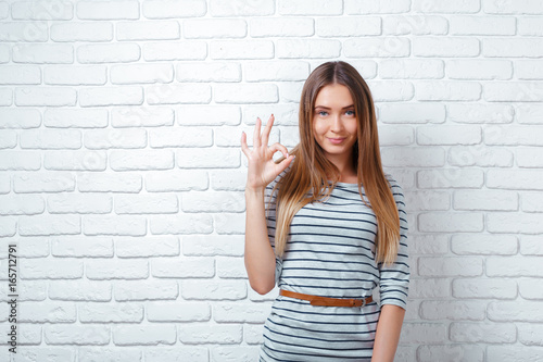 portrait of beautiful woman smiling while giving ok hand sign