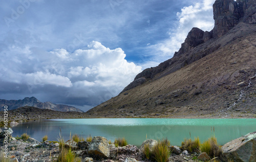 turquoise mountain lake with rocky edge and mountains in the Andes in Peru near Pastoruri photo