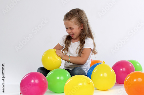 Kleines Mädchen sitzt zwischen Luftballons © Joerch