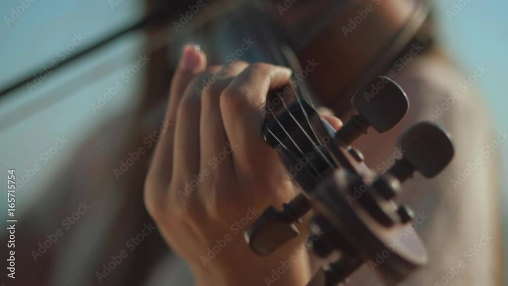 Girl violinist playing the violin outdoors. Green leaves backgound. Close up. Musician playing. Slow motion. Girl violinist playing the violin outdoors. Green leaves backgound. Close up. Musician playing. Slow motion.