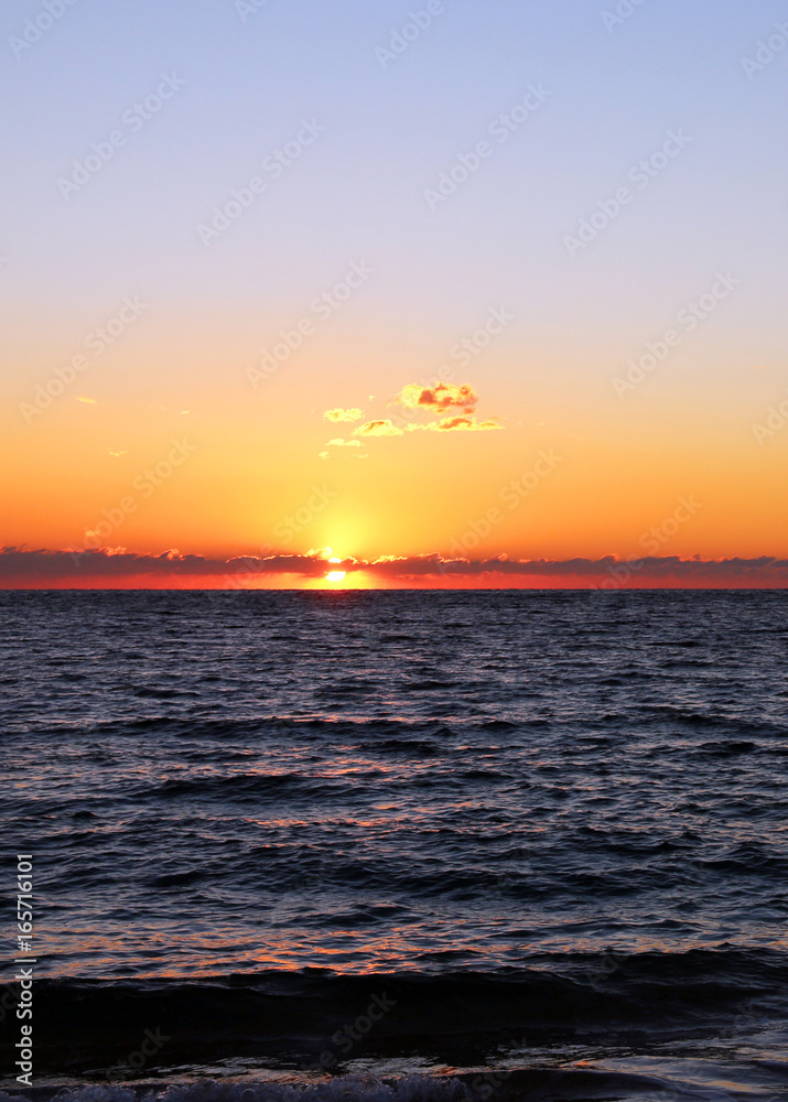 sunset behind clouds over the sea sunset behind clouds over the sea