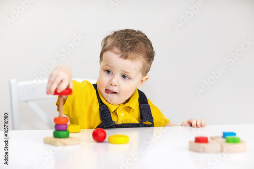 Фотография Concentrated little boy with toys on white background