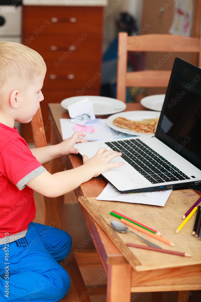 Little boy using laptop computer playing games Little boy using laptop computer playing games