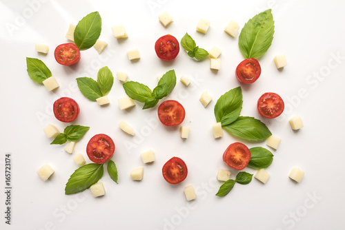 Tomatoes, cheese, Basil on a white background. Ingredients for pizza. Cute simple background, backdrop products of small size. Top view. Close-up. Stock photo Cooking concept.