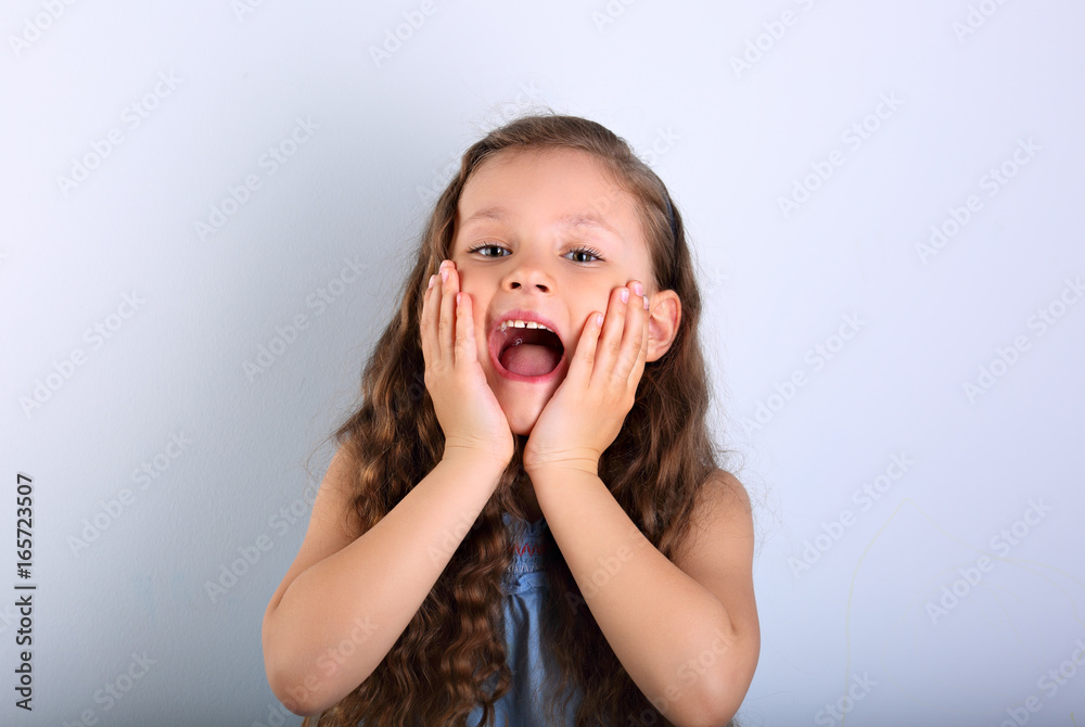 Excited surprising kid girl with wide open mouth and big eyes looking on empty copy space Excited surprising kid girl with wide open mouth and big eyes looking on empty copy space