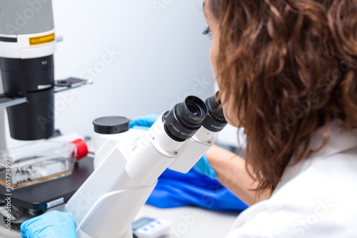Molecular biologist observing cancer cells at microscope © Alessandro Grandini
