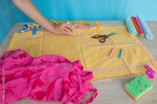 Seamstress hands on the work table with pattern and measuring tape