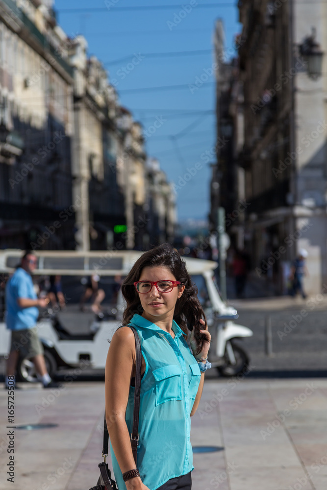 young girl in blue blouse and red glasses on the streets