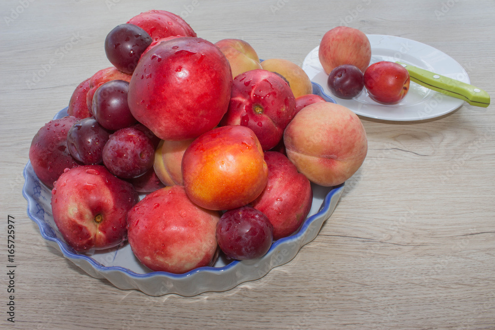 Fruit on the table. Peaches, nectarine, plums. Beautiful sweet peaches, nectarine and plums Fruit on the table. Peaches, nectarine, plums. Beautiful sweet peaches, nectarine and plums