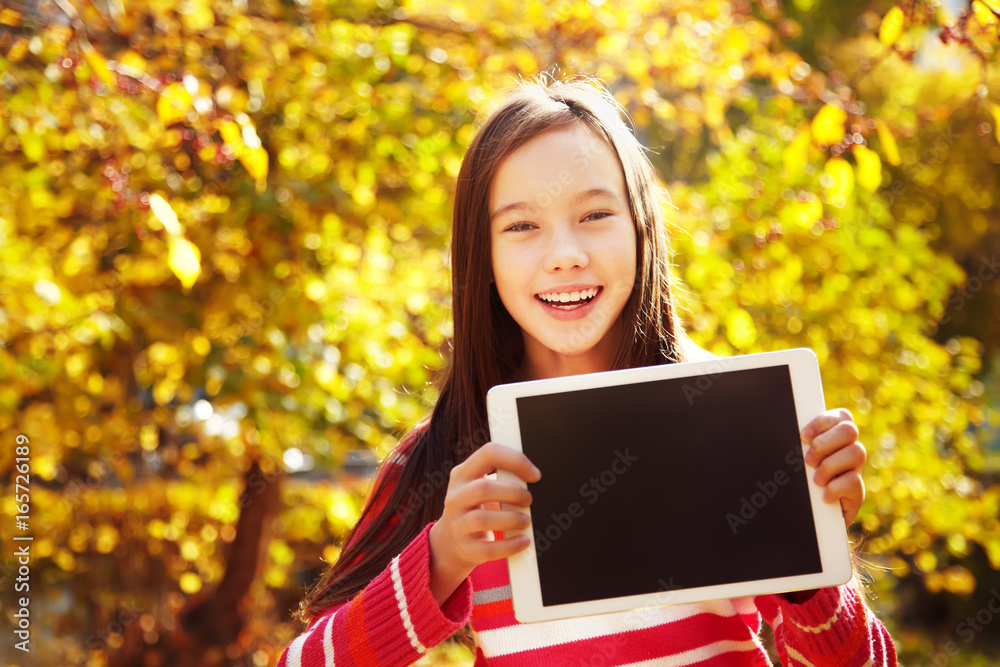 girl in autumn with tablet computer