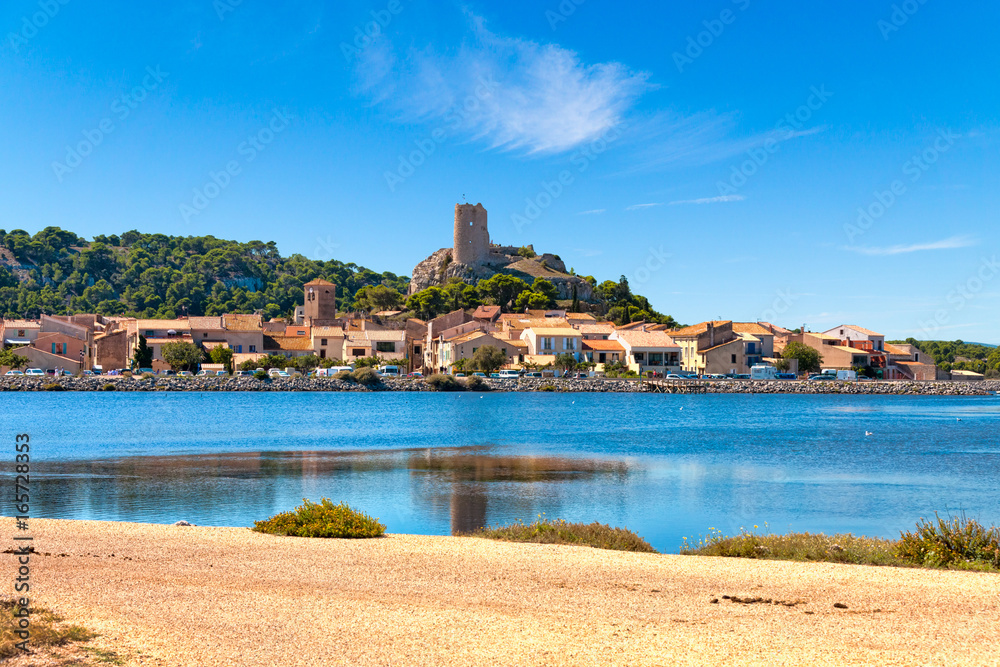 Blick auf den Ort Gruissan mit der Burgruine Tour Barberousse und dem Gewässer Etang de Gruissan in Südfrankreich.