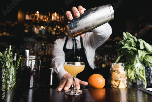 Foto Bartender pouring cocktail