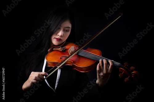 Playing the violin. Musical instrument with hands on dark background.