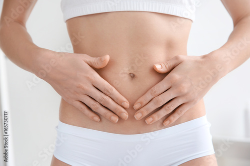 Closeup view of woman holding hands on her belly. Epilation concept