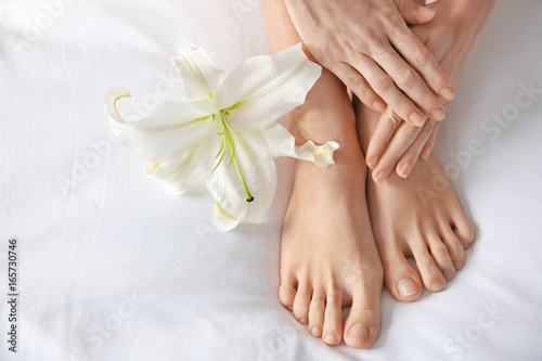 Female legs with flower on white fabric. Epilation concept